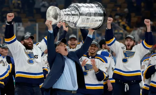 FILE - St. Louis Blues coach Craig Berube carries the Stanley Cup after the Blues defeated the Boston Bruins in Game 7 of the NHL Stanley Cup Final in Boston, June 12, 2019. (AP Photo/Michael Dwyer, File)