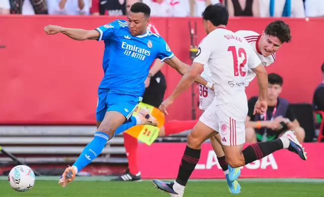 Real Madrid's Kylian Mbappe, left, controls the ball next to Sevilla's Gabriel Suazo and Sevilla's Joaquín Martínez Gauna during the Spanish La Liga soccer match at the Ramon Sanchez Pizjuan stadium in Seville, Spain, Sunday, May 17, 2026. (AP Photo/Jose Breton)