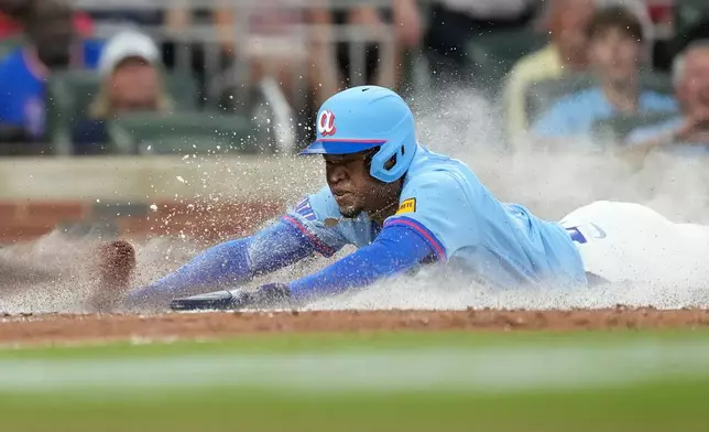 Atlanta Braves' José Azócar slides into home in the fifth inning of a baseball game against the Boston Red Sox Saturday, May 16, 2026, in Atlanta. (AP Photo/Brynn Anderson)