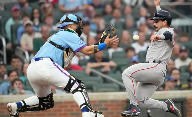 Boston Red Sox Mickey Gasper (30) slides safely into home against Atlanta Braves catcher Sandy León in the fourth inning of a baseball game Saturday, May 16, 2026, in Atlanta. (AP Photo/Brynn Anderson)