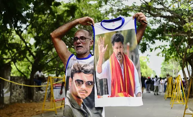 A worker of Tamilaga Vettri Kazhagam (TVK) party displays the photographs of party leader and actor-turned-politician, Vijay Chandrasekhar as he celebrates the early leads and results in the recently held state election, in Chennai, southern Indian state of Tamil Nadu, Monday, May 4, 2026. (AP Photo)