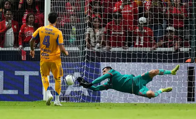 Toluca's goalkeeper Luis Garcia, right, blocks a shot by Tigres' Juan Purata during a penalty shootout on the CONCACAF Champions Cup final soccer match in Toluca, Mexico, Saturday, May 30, 2026. (AP Photo/Fernando Llano)