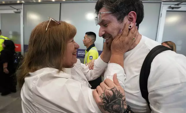 Kyle Adler, a 36-year-old Chilean American who was taken from his family at nine months old and illegally adopted, embraces his birth mother, Ana Maria Navarrete, after traveling from the U.S. to meet her for the first time, in Santiago, Chile, Saturday, Feb. 14, 2026. (AP Photo/Esteban Felix)