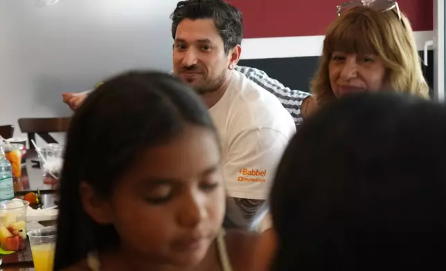 Kyle Adler, a 36-year-old Chilean American who was taken from his family at nine months old and illegally adopted, takes part in a family brunch alongside his birth mother, Ana Maria Navarrete, after traveling from the U.S. to meet her for the first time, in Santiago, Chile, Saturday, Feb. 14, 2026. (AP Photo/Esteban Felix)
