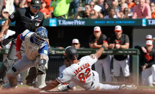 Baltimore Orioles' Jeremiah Jackson (82) avoids the tag by Toronto Blue Jays catcher Tyler Heineman and scores on a single by Gunnar Henderson during the third inning of a baseball game, Saturday, May 30, 2026, in Washington. (AP Photo/Terrance Williams)