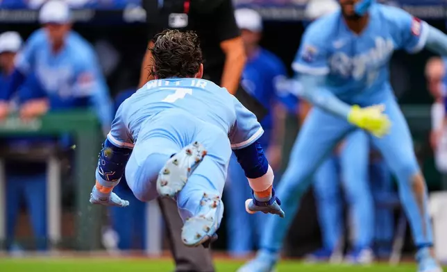 Kansas City Royals' Bobby Witt Jr. dives home to score after hitting a inside-the-park home run during the first inning of a baseball game against the Detroit Tigers, Saturday, May 9, 2026, in Kansas City, Mo. (AP Photo/Charlie Riedel)