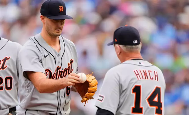 Detroit Tigers starting pitcher Burch Smith hands the ball to manager A.J. Hinch (14) during a pitching change in the first inning of a baseball game against the Kansas City Royals, Saturday, May 9, 2026, in Kansas City, Mo. (AP Photo/Charlie Riedel)