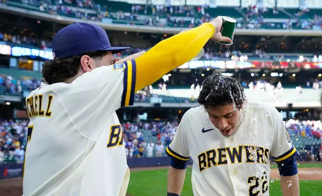 Milwaukee Brewers' Garrett Mitchell, left, douses Christian Yelich (22) after winning against the St. Louis Cardinals in a baseball game Wednesday, May 27, 2026, in Milwaukee. (AP Photo/Kayla Wolf)