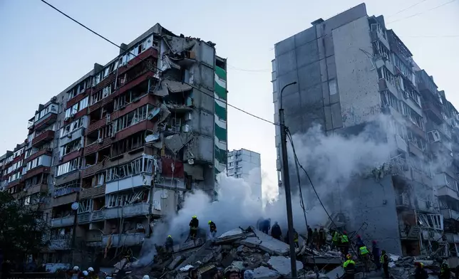 Rescue workers clear the rubble of a house heavily damaged after a Russian strike on a residential neighborhood in Kyiv, Ukraine, on Thursday, May 14, 2026. (AP Photo/Evgeniy Maloletka)