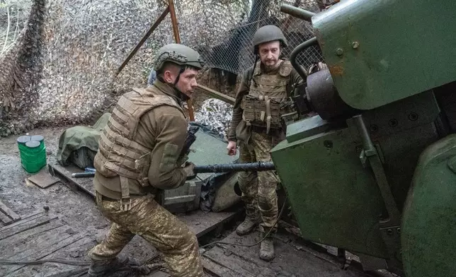 Soldiers from Ukraine's Khartia brigade fire a canon towards Russian army positions near Kharkiv, Ukraine, Thursday, May 14, 2026. (AP Photo/Andrii Marienko)