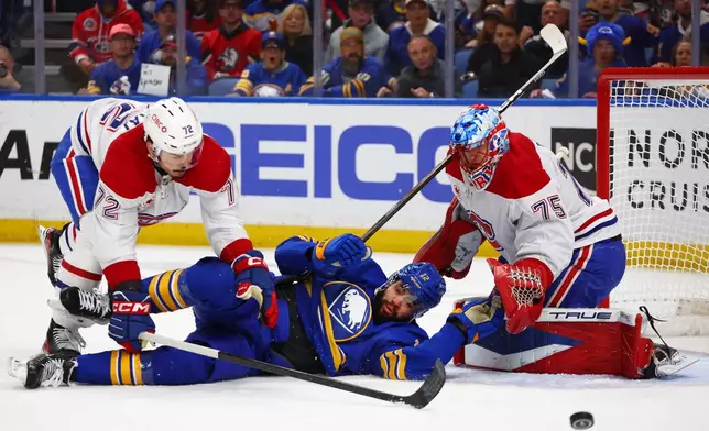 Buffalo Sabres left wing Jordan Greenway (12) is checked to the ice by Montreal Canadiens defenseman Arber Xhekaj (72) in front of goaltender Jakub Dobes (75) during the first period in Game 5 of a second-round NHL hockey Stanley Cup playoff series, Thursday, May 14, 2026, in Buffalo, N.Y. (AP Photo/Jeffrey T. Barnes)