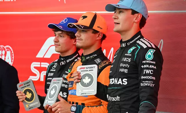 First place finisher Mercedes driver George Russell, right, of Britain, poses with from left, Mercedes driver Kimi Antonelli, of Italy, who placed third, and McLaren driver Lando Norris, of Britain, who finished in second place, following the sprint race at the F1 Canadian Grand Prix auto race in Montreal, Saturday, May 23, 2026. (Graham Hughes/The Canadian Press via AP)