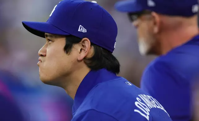 Los Angeles Dodgers pitcher Shohei Ohtani sits in the dugout during the first inning of a baseball game against the San Francisco Giants, Thursday, May 14, 2026, in Los Angeles. (AP Photo/Ryan Sun)