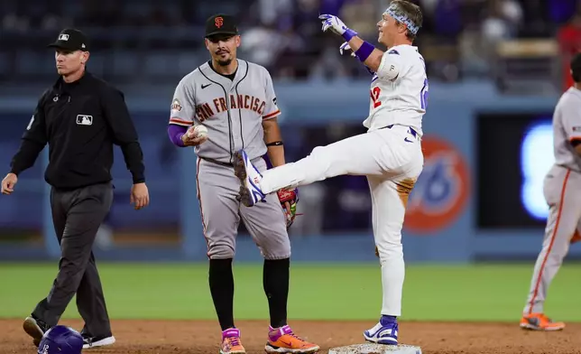 Los Angeles Dodgers' Alex Call, right, celebrates near San Francisco Giants shortstop Willy Adames after hitting an RBI single during the sixth inning of a baseball game Thursday, May 14, 2026, in Los Angeles. (AP Photo/Ryan Sun)