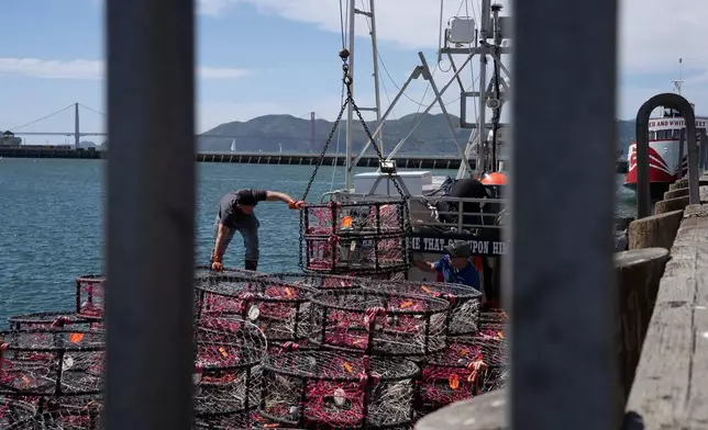 FILE - Hunter Nguyen, right, and Jonathan Tin, load crab traps, pop-up gear aimed at preventing whale entanglements, onto the boat Pale Horse at Pier 45 in San Francisco, April 10, 2025. (AP Photo/Emily Steinberger, File)