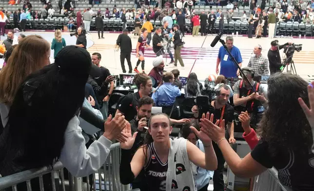 Toronto Tempo's Marina Mabrey, center, high fives-fans as she comes off the court after her team's first WNBA basketball game, against the Washington Mystics, in Toronto Friday, May 8, 2026. (Chris Young/The Canadian Press via AP)