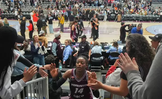 Toronto Tempo's Temi Fagbenle (14) high-fives fans as she comes off the court after her team's first WNBA basketball game, aganst the Washington Mystics, in Toronto, Friday, May 8, 2026. (Chris Young/The Canadian Press via AP)
