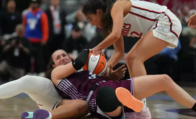 Toronto Tempo's Marina Mabrey, center, wrestles for the ball with Washington Mystics' Sonia Citron (22) and Kiki Iriafen, bottom, during second-half WNBA basketball game action in Toronto, Friday, May 8, 2026. (Chris Young/The Canadian Press via AP)