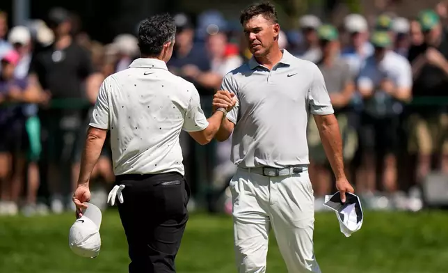 Rory McIlroy, of Northern Ireland, left, greets Brooks Koepka after they finished their round during the third round of the PGA Championship golf tournament at Aronimink Golf Club, Saturday, May 16, 2026, in Newtown Square, PA. (AP Photo/Frank Franklin II)