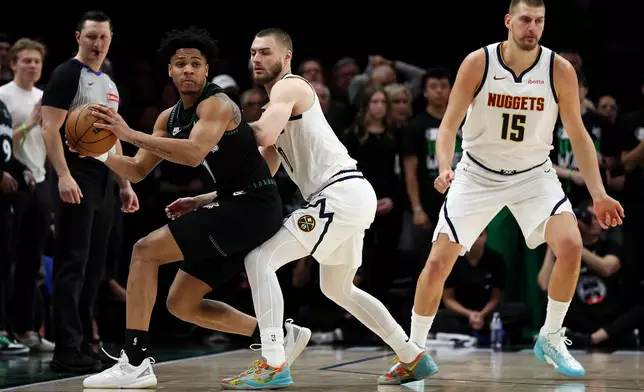 Minnesota Timberwolves guard Terrence Shannon Jr., left, controls the ball as Denver Nuggets guard Christian Braun, center, defends during the first half of Game 6 of a first-round NBA basketball playoffs series, Thursday, April 30, 2026, in Minneapolis. (AP Photo/Matt Krohn)