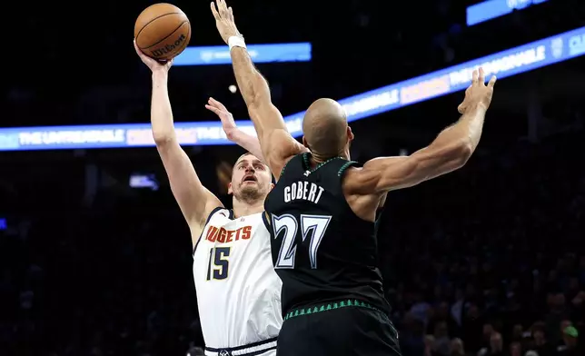 Denver Nuggets center Nikola Jokic, left, looks to shoot over Minnesota Timberwolves center Rudy Gobert (27) during the first half of Game 6 of a first-round NBA basketball playoffs series, Thursday, April 30, 2026, in Minneapolis. (AP Photo/Matt Krohn)