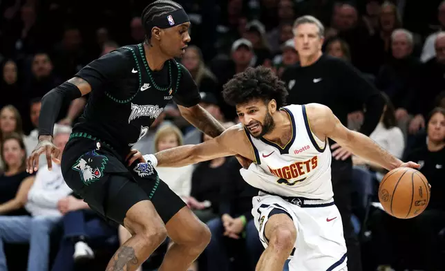 Denver Nuggets guard Jamal Murray, right, controls the ball as Minnesota Timberwolves forward Jaden McDaniels, left, defends during the first half of Game 6 of a first-round NBA basketball playoffs series, Thursday, April 30, 2026, in Minneapolis. (AP Photo/Matt Krohn)