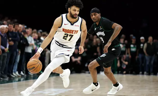 Denver Nuggets guard Jamal Murray, left, works around Minnesota Timberwolves forward Jaden McDaniels, right, during the first half of Game 6 of a first-round NBA basketball playoffs series, Thursday, April 30, 2026, in Minneapolis. (AP Photo/Matt Krohn)