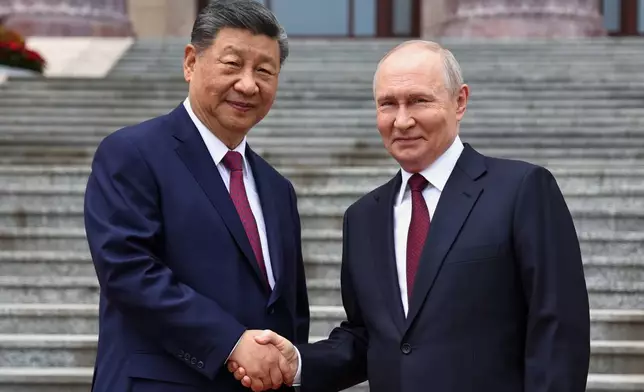 Russian President Vladimir Putin, right, and Chinese President Xi Jinping shake hands during a welcome ceremony at the Great Hall of the People, in Beijing, China, on Wednesday, May 20, 2026. (Alexander Kazakov, Sputnik, Kremlin Pool Photo via AP)