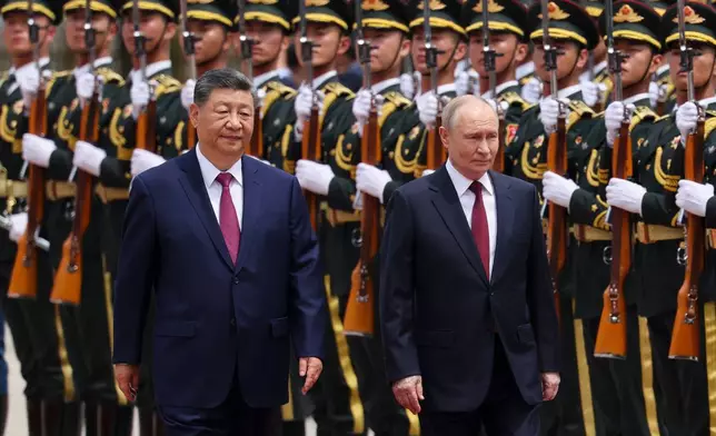 Russian President Vladimir Putin, right, and Chinese President Xi Jinping inspect an honor guard during a welcoming ceremony at the Great Hall of the People in Beijing Wednesday, May 20, 2026. (Maxim Shemetov/Pool Photo via AP)