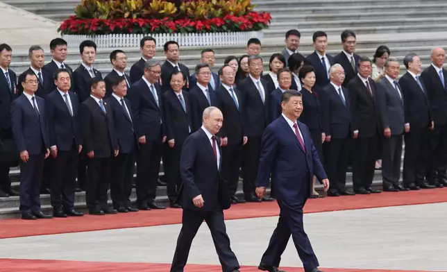 Russian President Vladimir Putin, left, walks with Chinese President Xi Jinping during a welcoming ceremony at the Great Hall of the People in Beijing Wednesday, May 20, 2026. (Maxim Shemetov/Pool Photo via AP)