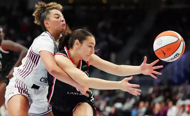 Toronto Tempo's Kiki Rice, left, and Portland Fire's Carla Leite, right, battle for the ball during second-half WNBA basketball game action in Toronto, Saturday May 23, 2026. (Frank Gunn/The Canadian Press via AP)