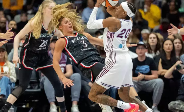 Toronto Tempo guard Brittney Sykes (20) picks up an offensive foul as she drives through Portland Fire guard Sarah Ashlee Barker (3) during the first half of a WNBA basketball game in Toronto, Saturday May 23, 2026. (Frank Gunn/The Canadian Press via AP)
