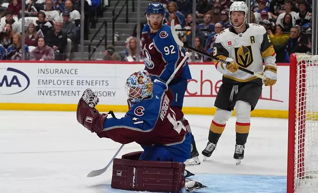 Colorado Avalanche goaltender Scott Wedgewood, front, makes a glove save as left wing Gabriel Landeskog, back left, and Vegas Golden Knights center Jack Eichel looks on during the second period in Game 1 of the Western Conference finals NHL hockey Stanley Cup playoff series Wednesday, May 20, 2026, in Denver. (AP Photo/David Zalubowski)