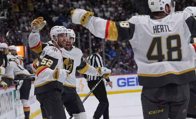 Vegas Golden Knights defenseman Dylan Coghlan, front left, is congratulated after scoring a goal by defenseman Shea Theodore, back left, and center Tomas Hertl during the second period in Game 1 of the Western Conference finals NHL hockey Stanley Cup playoff series against the Colorado Avalanche Wednesday, May 20, 2026, in Denver. (AP Photo/David Zalubowski)