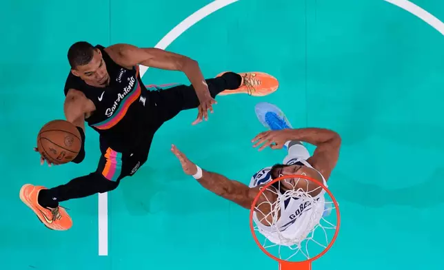 San Antonio Spurs forward Victor Wembanyama (1) drives to the basket against Minnesota Timberwolves center Rudy Gobert (27) during the first half in Game 1 of a second-round NBA playoffs basketball series in San Antonio, Monday, May 4, 2026. (AP Photo/Eric Gay)
