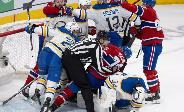 Montreal Canadiens and Buffalo Sabres scuffle in the crease behind Buffalo Sabres goaltender Alex Lyon (34) during the first period of Game 3 in a second-round NHL hockey Stanley Cup playoff series in Montreal, Sunday, May 10, 2026. (Christinne Muschi/The Canadian Press via AP)