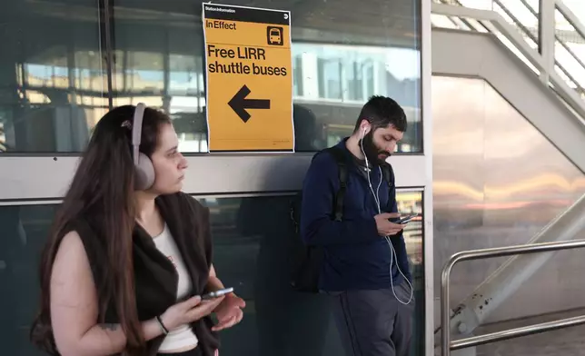 Signs for free Long Island Rail Road shuttle buses hang at the Howard Beach–JFK Airport station as Long Island Rail Road workers enter the third day of their strike, Monday, May 18, 2026, in New York. (AP Photo/Heather Khalifa)