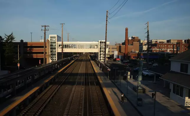 A pedestrian walks along an empty track at Mineola train station as Long Island Rail Road workers strike, Monday, May 18, 2026, in Mineola, N.Y. (AP Photo/Heather Khalifa)