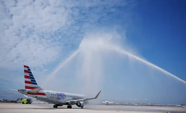 American Airlines Flight AA3599, the first direct commercial flight between the United States and Venezuela in seven years, gets a water cannon salute as it taxis away from the gate, Thursday, April 30, 2026, at Miami International Airport in Miami. (AP Photo/Rebecca Blackwell)