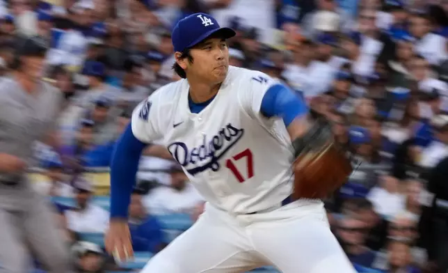 Los Angeles Dodgers pitcher Shohei Ohtani, right, throws to the plate during the first inning of a baseball game against the Colorado Rockies, Wednesday, May 27, 2026, in Los Angeles. (AP Photo/Mark J. Terrill)