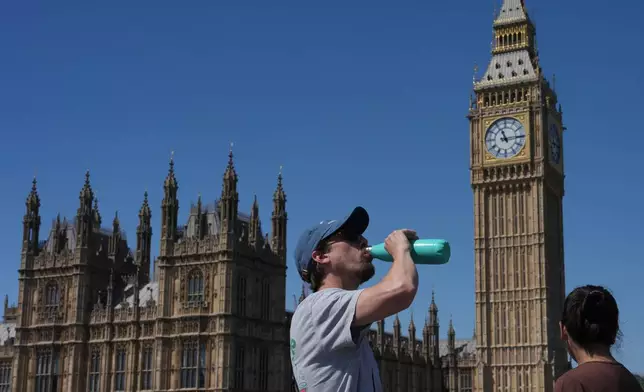 A man drinks outside the Palace of Westminster in London, Tuesday, May 26, 2026. (AP Photo/Kin Cheung)