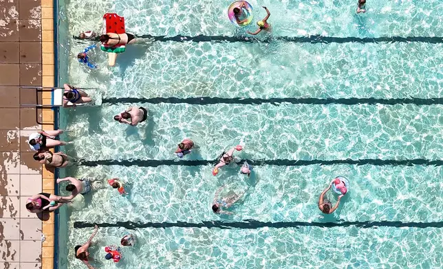 Swimmers keep cool in the hot weather in an open-air pool in Letchworth Garden City, Hertfordshire, England, Tuesday May 26, 2026. (Joe Giddens/PA via AP)
