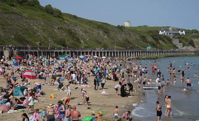 People enjoying the warm weather on Sunny Sands beach in Folkestone, England, Saturday May 23, 2026. (Gareth Fuller/PA via AP)