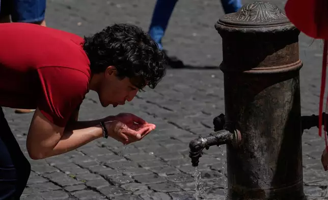 A man drinks water at a fountain in downtown Rome as temperatures are expected to reach 32 degrees Celsius (89.6 Fahrenheit), Tuesday, May 26, 2026. (AP Photo/Gregorio Borgia)