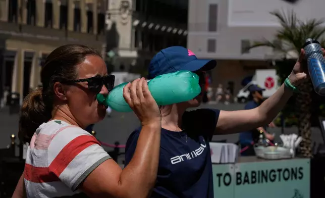 A woman drinks water from a frozen bottle in downtown Rome as temperatures are expected to reach 32 degrees Celsius (89.6 Fahrenheit), Tuesday, May 26, 2026. (AP Photo/Gregorio Borgia)