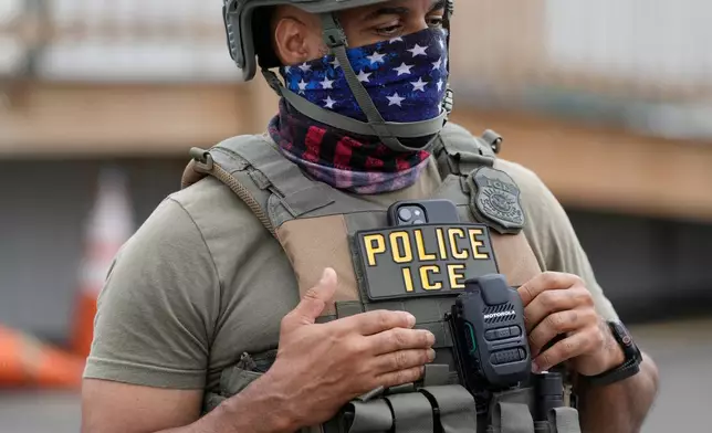 A masked ICE agent stands outside the Delaney Hall detention center during a protest against the transfer of detainees on Wednesday, May 27, 2026, in Newark, N.J. (AP Photo/Seth Wenig)