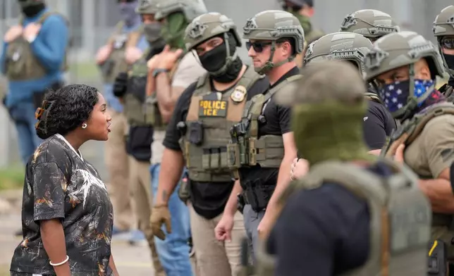 A protester talks to masked federal agents standing outside the Delaney Hall detention center during a protest against the transfer of detainees on Wednesday, May 27, 2026, in Newark, N.J. (AP Photo/Seth Wenig)