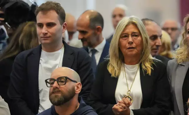 Niccolò Zanardi, son, and Daniela Manni, wife, of Alex Zanardi, Italian auto racing champion-turned-Paralympic gold medalist, attend his funeral inside the Basilica of Santa Giustina, Padua, Italy, Tuesday, May 5, 2026. (Claudio Furlan/LaPresse via AP)