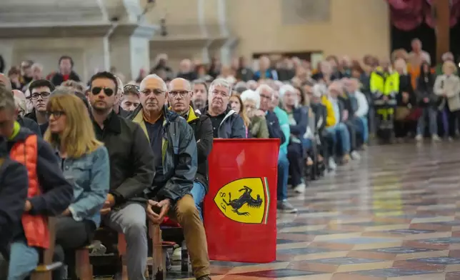 A Ferrari flag is displayed as people attend the funeral of Alex Zanardi, Italian auto racing champion-turned-Paralympic gold medalist, inside the Basilica of Santa Giustina, Padua, Italy, Tuesday, May 5, 2026. (Claudio Furlan/LaPresse via AP)