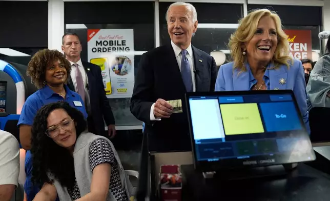 FILE - President Joe Biden, center, and first lady Jill Biden, right, pay for a purchase as they greet supporters at a Waffle House in Marietta, Ga., June 28, 2024, following a presidential debate in Atlanta. (AP Photo/Evan Vucci, File)
